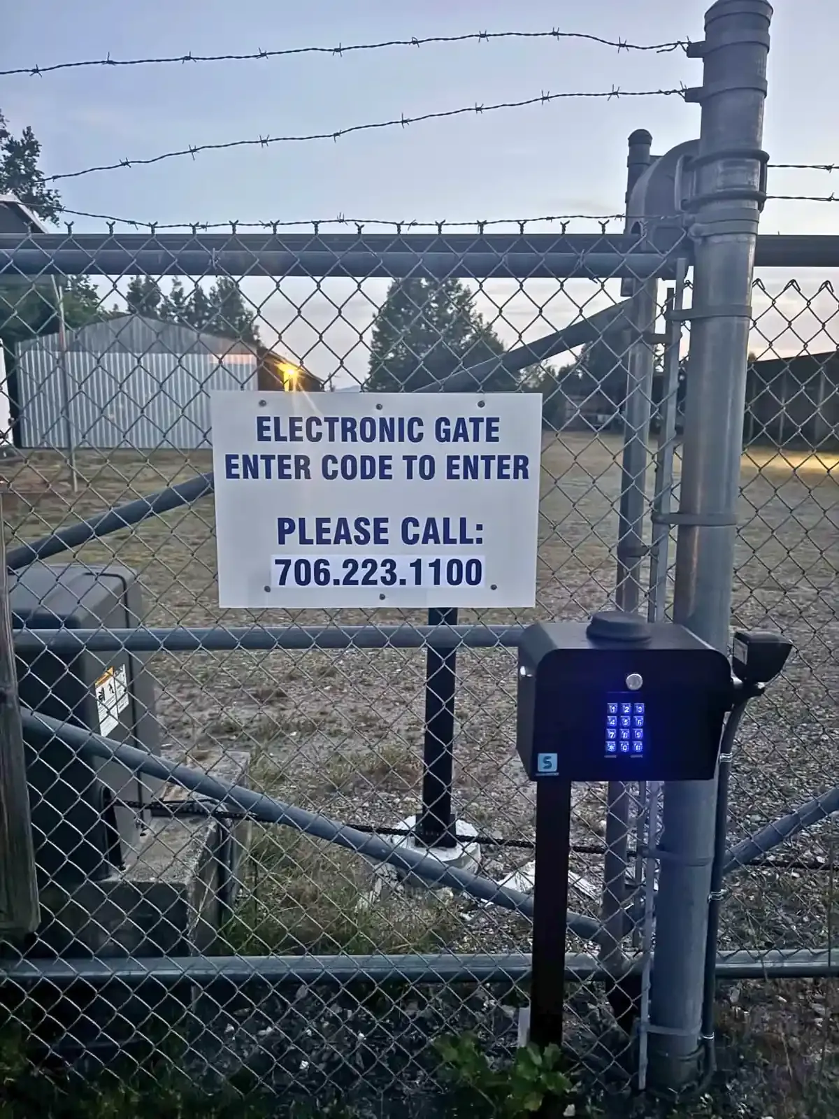 Chain link fence with electronic gate access sign
